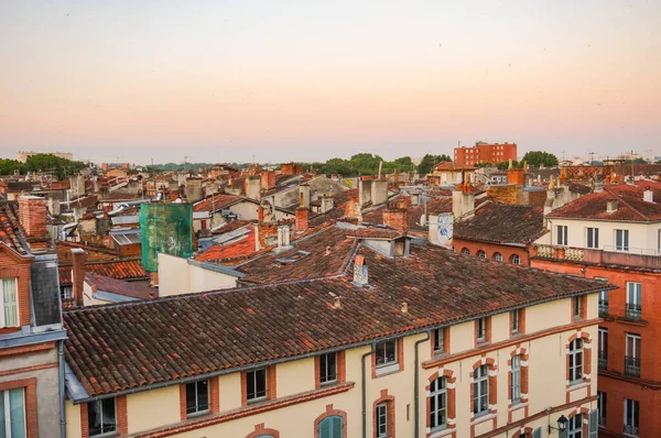 Elevated view over ancient, Southern-style town buildings, constructed in traditional brick on Rue Pharaon Street, in the historic neighborhood of Carmes, in the city center of Toulouse, France