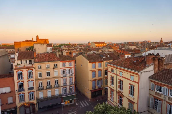 Toulouse, France - Feb. 2020 - Typical brick southern townhouses seen from the multi-storey car park in Place des Carmes, in the most expensive neighborhood of Toulouse, featuring old wooden shutters
