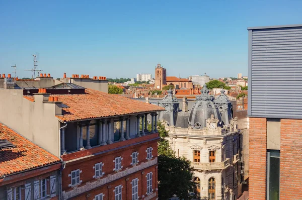 Toulouse, France - Feb. 2020 - Typical brick southern townhouses seen from the multi-storey car park in Place des Carmes, in the most expensive neighborhood of Toulouse, featuring old wooden shutters