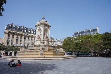 Paris, Fransa - 5 Eylül 2023 - Saint-Sulpice Meydanı, başkentin altıncı yüzyıldaki meydanı, merkezinde tarihi, oyulmuş Saint-Sulpice Çeşmesi