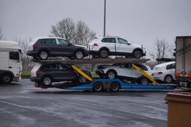 Brive-la-Gaillarde, Fransa - 26 Aralık 2022 - Paris ile Güney arasındaki işlek A20 otoyolunun yakınındaki bir dinlenme alanına park etmiş bir araba taşıyan araçlar soğuk ve yağmurlu bir kış gününde