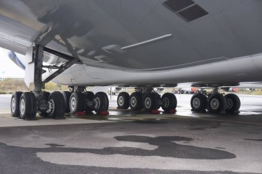 Toulouse, Fransa - 21 Kasım 2023 - İniş takımlarının tekerlekleri, pistte park edilmiş bir AIrbus A380 'in altında; iniş takımı ve lastikler Fransız üreticiler Safran ve Michelin tarafından yapıldı