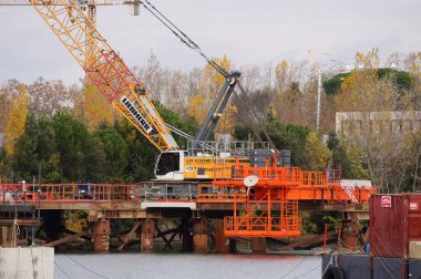 Labge, Fransa - 2 Aralık 2023 - Toulouse metrosunun B hattının genişletilmesi için viyadük inşaatının yapıldığı Labge INPT Gölü 'nde, suyun üzerinde bir kıyı platformunda Craler vinç