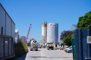 Toulouse, Fransa - 9 Ağustos 2023 - CEMEX 'in Toulouse Arospace iş parkındaki çimento fabrikası; uzaktan, gelecekteki Montaudran Gare Metro İstasyonunun inşaat sahasında sürüngen vinç