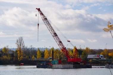 Labge, Fransa - 2 Aralık 2023 - Toulouse metrosunun B hattının genişletilmesi için viyadük inşaatının yapıldığı Labge INPT Gölü 'nde, suyun üzerinde bir kıyı platformunda Craler vinç