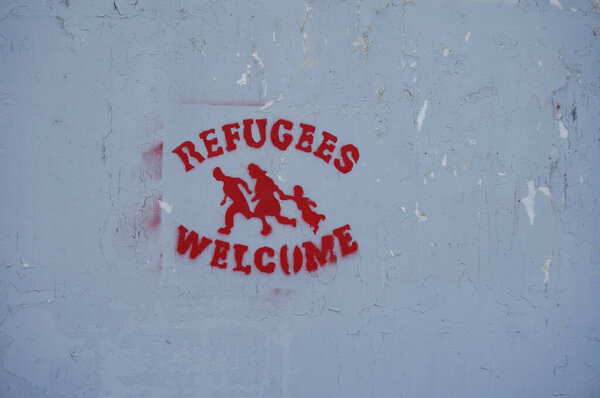 Toulouse, France - March 15, 2024 - Red tag stating "Refugees welcome" on a wall of Toulouse III-Paul Sabatier University, by 3R3, a building squatted by far-left militias and irregular immigrants