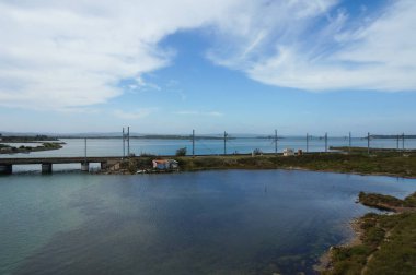 Port-la-Nouvelle, Fransa - 5 Nisan 2024 - Berre ve Bages-Sigean Lagünleri, Berre Nehri 'nin Akdeniz' e aktığı yer; elektrikli bir TGV hattı olan bir demiryolu köprüsü adaları geçer
