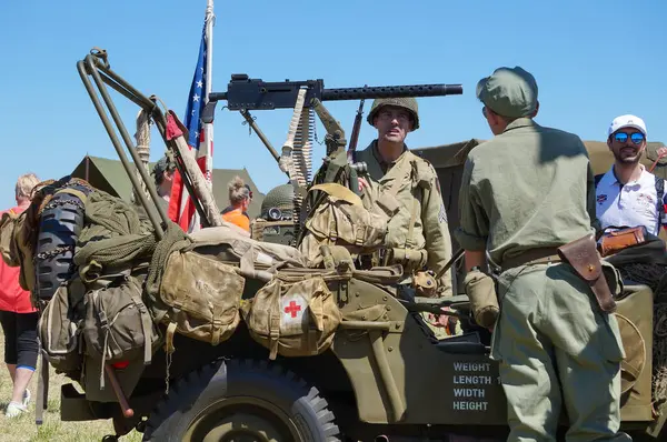 stock image Lherm, France - May 11, 2024 - Historical reenactment of a World War II US military camp on the airfield of Muret-Lherm, during AirExpo show: figurants around a Jeep armed with a Browning machine gun