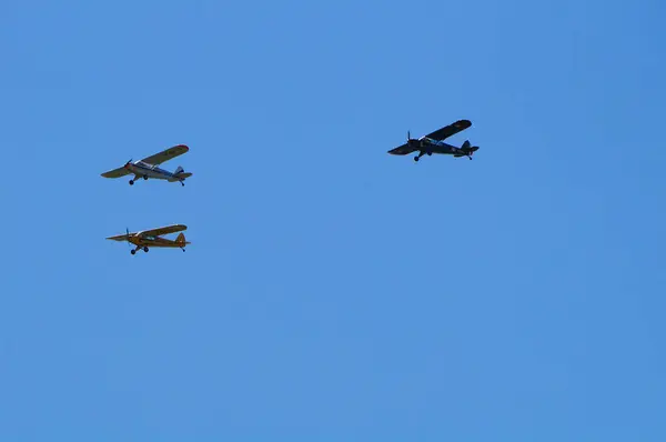 stock image Lherm, France - May 11, 2024 - Formation flight with 3 Piper Cub light aircrafts with the Crazy Piper Team, a private French aerobatic team, performing at AirExpo show at Muret-Lherm Aerodrome