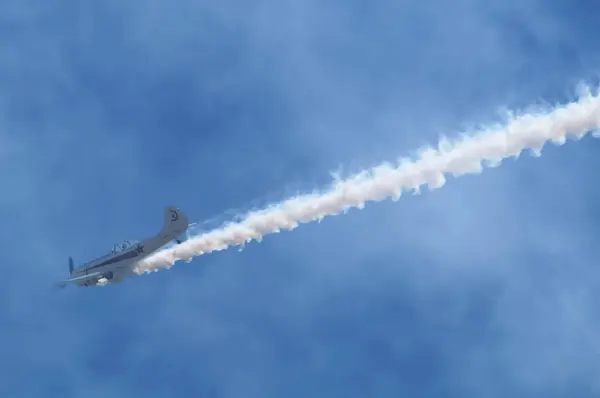 stock image Lherm, France - May 11, 2024 - A Yakvolvev Yak-50, a Soviet trainer aircraft from the 1980s, performs aerobatic stunts while emitting white smoke at AirExpo air show at Muret-Lherm Aerodrome