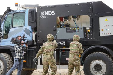 Paris Nord Villepinte, France - June 26, 2024 - The French KNDS CBRN team in full suits, in live demonstration with an Essential Decon system based on a Mercedes Unimog truck, at Eurosatory arms fair