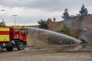 Paris Nord Villepinte, Fransa - 25 Haziran 2024 - Fransız üretici SIDES 'in itfaiye aracı, Renault kamyonuna dayalı, Eurosatory silah fuarındaki canlı gösteri sırasında su topu ile bir şenlik ateşi yaktı