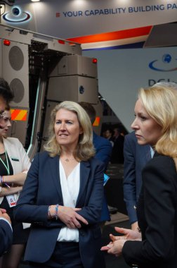 Paris Nord Villepinte, France - June 25, 2024 - Conservative MEPs Marion Marchal and Laurence Trochu visit the stand of Arquus, a French manufacturer of armored vehicles, during the Eurosatory Fair clipart