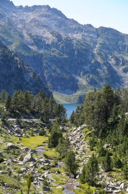 Nouvielle, France - July 22, 2024 - Peak of Nouvielle in the French Pyrenees, in Nouvielle Natural Park; on the valley floor, a small mountain stream flows towards Aubert Lake, in the background clipart