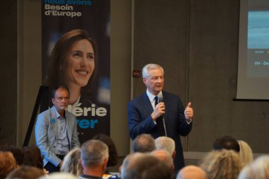 Saint-Orens, France - June 3, 2024 - Minister Bruno Le Maire speaks during a rally amid the campaign for the European elections; behind him is an election poster with the portrait of MEP Valrie Hayer clipart