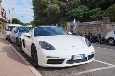 Antibes, Fransa - 22 Ekim 2024 Alman lüks üreticisi Porsche 'den üstü açık beyaz bir 718 Boxster, zengin Juan-les-Pins mahallesindeki lüks bir otelin önüne park etmiş.