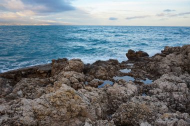 Antibes, Fransa - 25 Ekim 2024 - Cte d 'Azur' da (Fransız Rivierası) lüks bir sahil beldesi olan Cap d 'Antibes yarımadasının kayalık kıyılarında, yabani bir koydan Akdeniz' e gece görüşü)