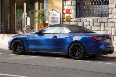Antibes, Fransa - 22 Ekim 2024 Alman lüks araba üreticisi BMW 'den üstü açık mavi 4 Serisi M4 Cabriolet Juan-les-Pins' in zengin mahallesindeki lüks bir otelin önünde park edilmiş.