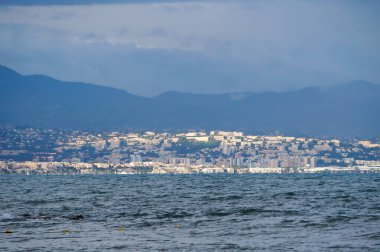 Antibes, France - Oct. 25, 2024 - Seen from Ponteil Beach, the seaside towns of Villeneuve-Loubet and Cagnes-sur-Mer on the Mediterranean Sea, at the foot of the Maritime Alps in the French Riviera clipart