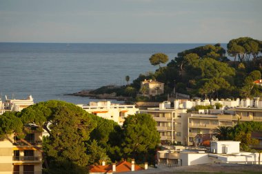 Antibes, France - Oct. 21, 2024 - Sunset view on the Garoupe side of the peninsula of Cap d'Antibes, seen from the beach resort of Juan-Les-Pins, Cte-d'Azur (French Riviera) on the Mediterranean Sea clipart