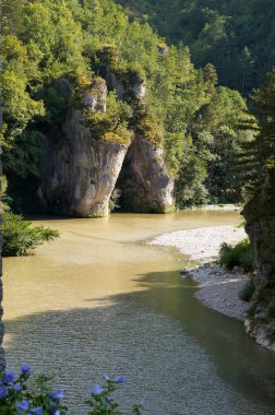 Saint-Chly-du-Tarn, Fransa - Ağustos. 15, 2024 Tarn Nehri, ıssız çakıl taşı plajı ve Gorges du Tarn Causses kanyonundaki kayalık uçurumlar, Lozre kırsalının uzak bir bölgesi.