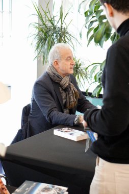 Toulouse, France - Jan. 28, 2025 - French Air Force Colonel Philippe Perrin, former astronaut with CNES, ESA and NASA space agencies) signs his last book at the Institute of Aeronautics and Space clipart