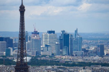 Paris, Fransa - 22 Haziran 2024 - Fransa başkentinin ufuk çizgisi üzerinde Montparnasse Kulesi 'nden gökyüzü manzarası: önde Eyfel Kulesi ve arka planda La Dfense İş Bölgesi gökdelenleri
