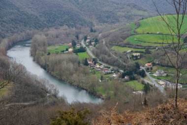 Ambialet, Fransa - 8 Mart 2025 - Occitanie 'de Tarn Nehri' nin çevrelediği kayalık bir çıkıntının yamacında yuva yapmış Ambialet 'in tarihi ve üst kesiminin havadan görünüşü