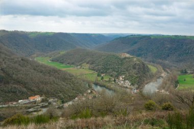 Ambialet, Fransa - 8 Mart 2025 - Occitanie 'de Tarn Nehri' nin çevrelediği kayalık bir çıkıntının yamacında yuva yapmış Ambialet 'in tarihi ve üst kesiminin havadan görünüşü