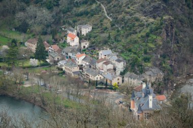 Ambialet, Fransa - 8 Mart 2025 - Occitanie 'de Tarn Nehri' nin çevrelediği kayalık bir çıkıntının yamacında yuva yapmış Ambialet 'in tarihi ve üst kesiminin havadan görünüşü