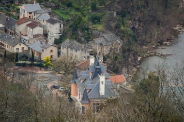 Ambialet, Fransa - 8 Mart 2025 - Occitanie 'de Tarn Nehri' nin çevrelediği kayalık bir çıkıntının yamacında yuva yapmış Ambialet 'in tarihi ve üst kesiminin havadan görünüşü