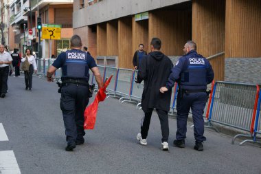 Toulouse, Fransa - 8 Mayıs 2025 - Komünist bayrağına el konulmuş aşırı sol aktivist, Vatanseverlik Günü 'nde halkın huzurunu bozduktan ve bağırdıktan sonra şehir polisi tarafından dışarı çıkarıldı.