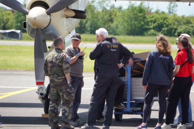 Muret, Fransa - 10 Mayıs 2025 - Amerikan OV-10 saldırı uçağının motoruyla konuşan havacılar: Fransız Ordusu Hafif Havacılık 'tan havacı, sivil mürettebat, AirExpo fuarının genç organizatörleri