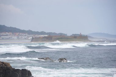 Dalgalar kalenin yakınındaki kayalık kıyı şeridine çarpıyor