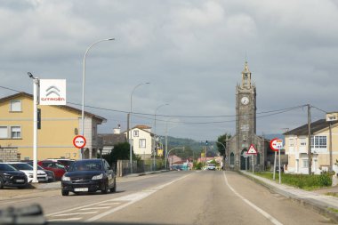 Guarda, İspanya - 13 Haziran 2025 - Pontevedra Eyaleti 'ndeki La Guardia' nın Salcidos ilçesinde ana cadde: San Roque Kilisesi ve Fransız otomotiv markası Citron 'dan bir araba galerisi