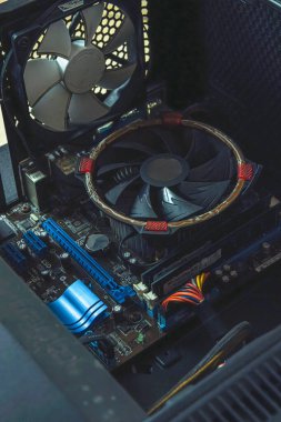 Kırık bir masaüstü bilgisayar çantasının iç görüntüsü, bir bilgisayar ana kartı, işlemci fan ve bileşenlerini gösterir.