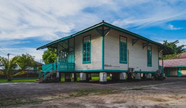 Dahor Miras Stilt Evi 'nin yan görüntüsü. Balikpapan, Endonezya - 11 Mart 2024. Hollandalı sömürgeciler tarafından 1900 'lerde inşa edilen Dahor Evi, Balikpapan' ın Hollanda sömürge dönemi petrol arama tarihine tanıklık ediyor..