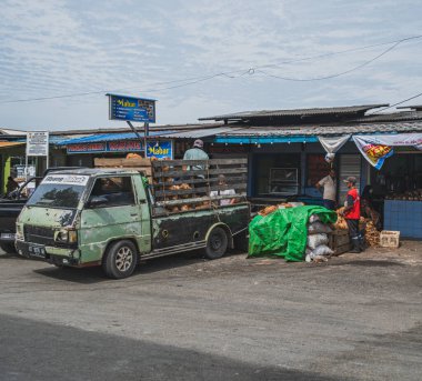 Balikpapan, Endonezya - 15 Mart 2024 Bazı insanlar hindistan cevizi fuit yığınını kamyondan hindistan cevizi tezgahına boşaltmaya başlıyor..