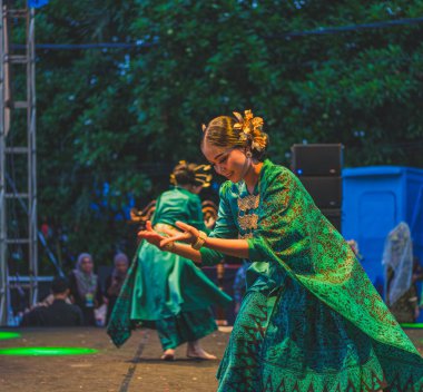 Balikpapan, Indonesia - June 5th, 2024. they are performing Palembang traditional dance live on stage at culture carnival show. clipart