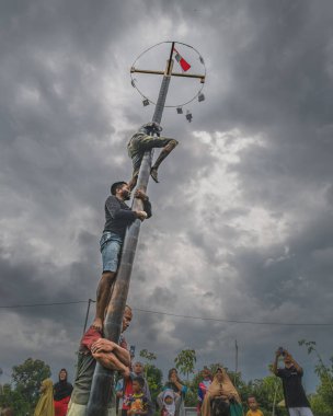 Balikpapan, Endonezya - 18 Ağustos 2024. Panjat Pinang ya da palmiye ağacı tırmanma yarışması, 17 Ağustos 'ta Bağımsızlık Günü' nde sıklıkla düzenlenen popüler bir Endonezya geleneği..