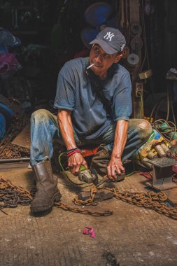 Balikpapan, Endonezya - 26 Haziran 2024 Adam atölyesinin önünde çalışıyor.