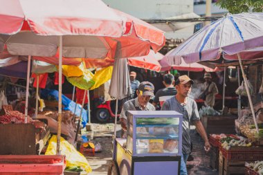 Balikpapan, Endonezya - 26 Haziran 2024. Yaşlı dondurmacı güneşli bir günde dondurma ve ekmek satar..