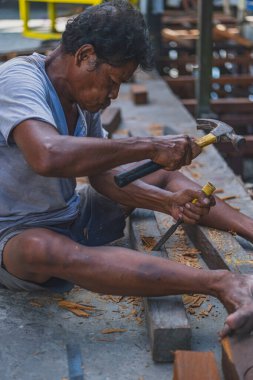 Balikpapan, Endonezya - 26 Haziran 2024 Balikpapan 'da küçük bir liman botu veya Pelabuhan Klotok yakınlarında ahşap bir platform yapmak için çalışıyor..