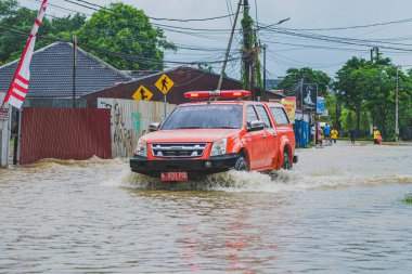 Balikpapan, Endonezya - 9 Ağustos 2024. Güçlü akıntı yüzünden selin içinden geçmek için mücadele ediyor..