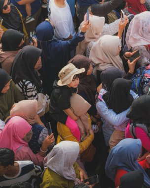 Balikpapan, Endonezya - 9 Kasım 2024. Annesiyle birlikte geçit törenini izliyorlar..