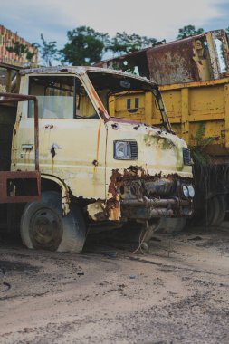 Balikpapan, Endonezya - 19 Kasım 2024. Hurdalıkta paslı bir kamyonun yakın çekimi bozulma ve çürüme detaylarını vurguluyor..