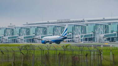 Balikpapan, Endonezya - 13 Ocak 2025. Pist boyunca bir ticari jet taksisi, yolculuğuna hazırlanıyor..