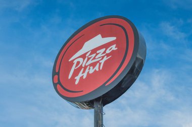 Balikpapan, Endonezya - 18 Ocak 2025. Mavi gökyüzüne karşı ikonik Pizza Hut tabelasının yakın çekimi. Kırmızı ve beyaz logo popüler pizza zincirinin tanınabilir bir sembolüdür..