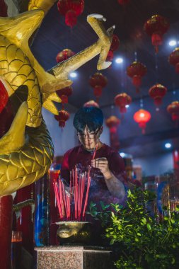 Balikpapan, Endonezya - 28 Ocak 2025. Bir tapınakta duasını bitirdikten sonra tütsüyü bir sansüre yerleştirir..