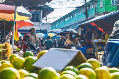 Balikpapan, Endonezya 19 Nisan 2025. Bir market satıcısı geleneksel baharat tezgahında yeşil biber kepçesini plastik poşete dolduruyor..